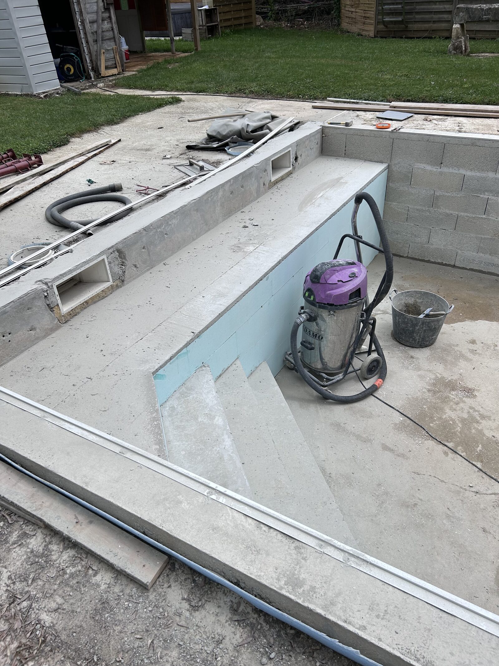 Betonnen bad in voorbereiding: trap, skimmers en isolatie voor de liner