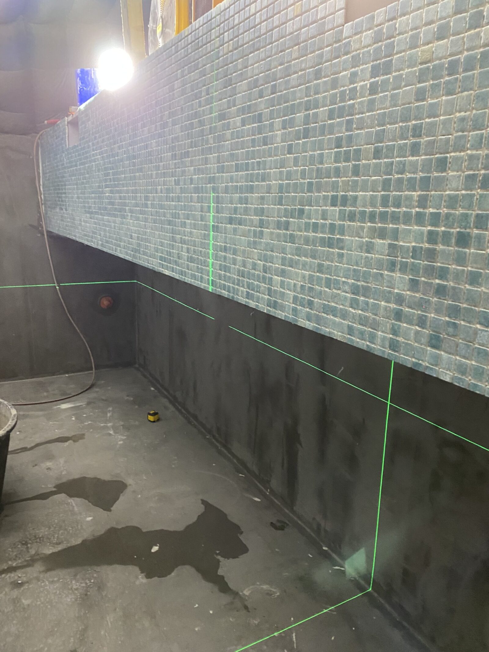 Plaatsing van wandmozaïek met laser voor een perfecte uitlijning