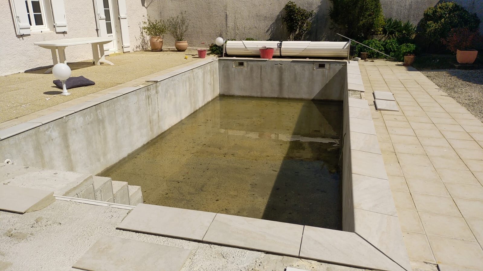 Zwembad voor renovatie, leeg en beschadigd